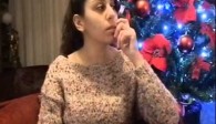 We see Hiba Najem sitting in front of a christmas tree