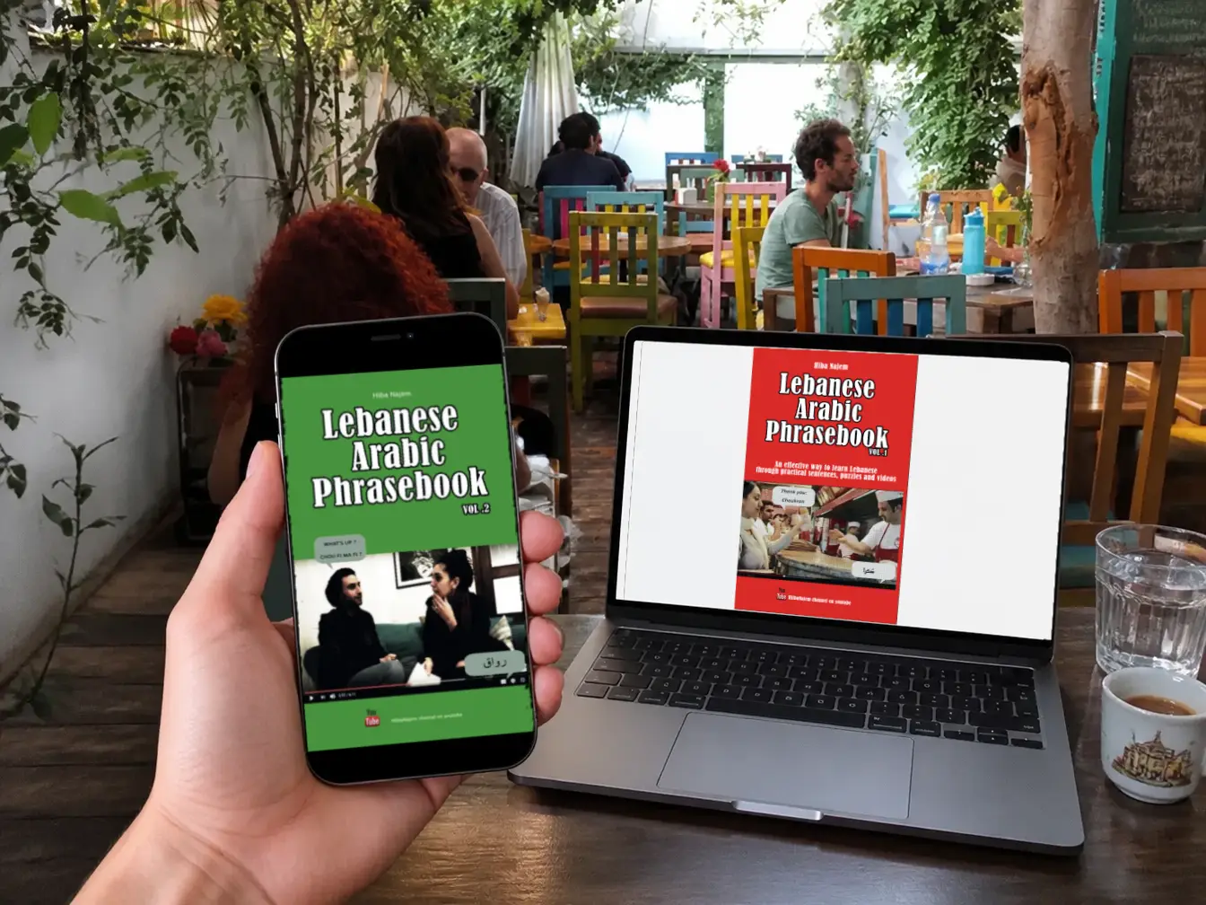 The Lebanese Arabic Phrasebooks PDFs loaded on a phone and a laptop in a coffeeshop